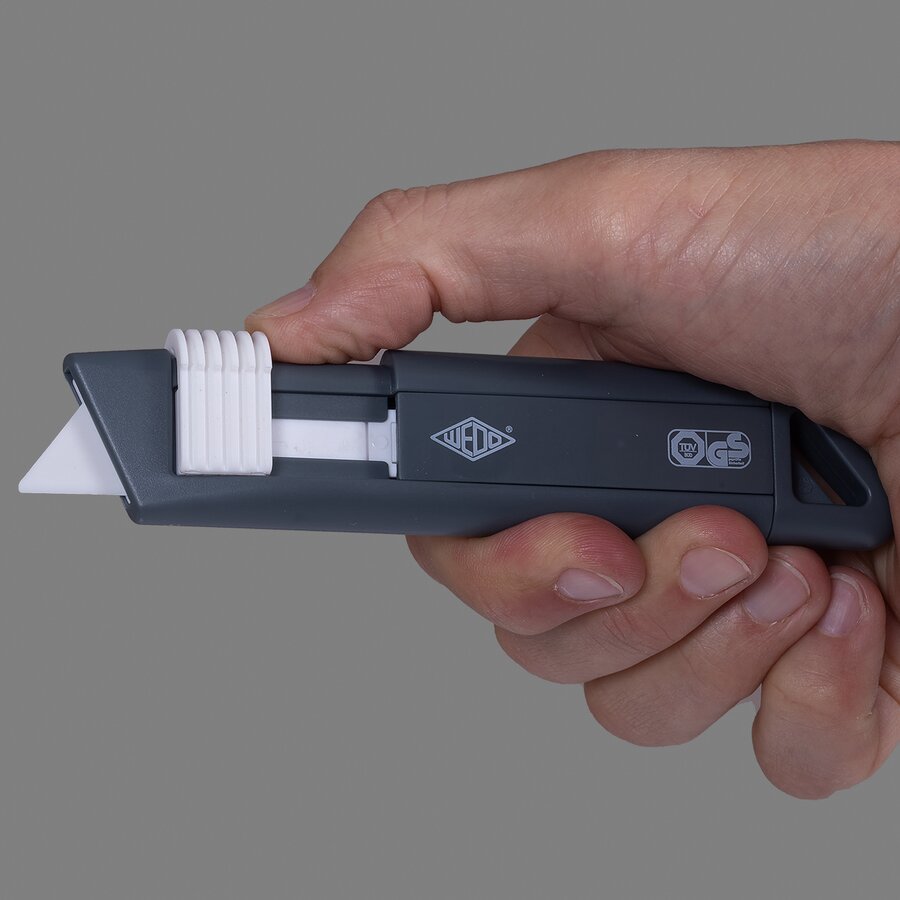 Die schneidstarke Keramikklinge zieht sich automatisch zurück, sobald der Klingenschieber losgelassen wird Die schneidstarke Keramikklinge zieht sich automatisch zurück, sobald der Klingenschieber losgelassen wird