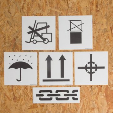 6 Hinweisetiketten aufgeklebt auf einer Holzkiste